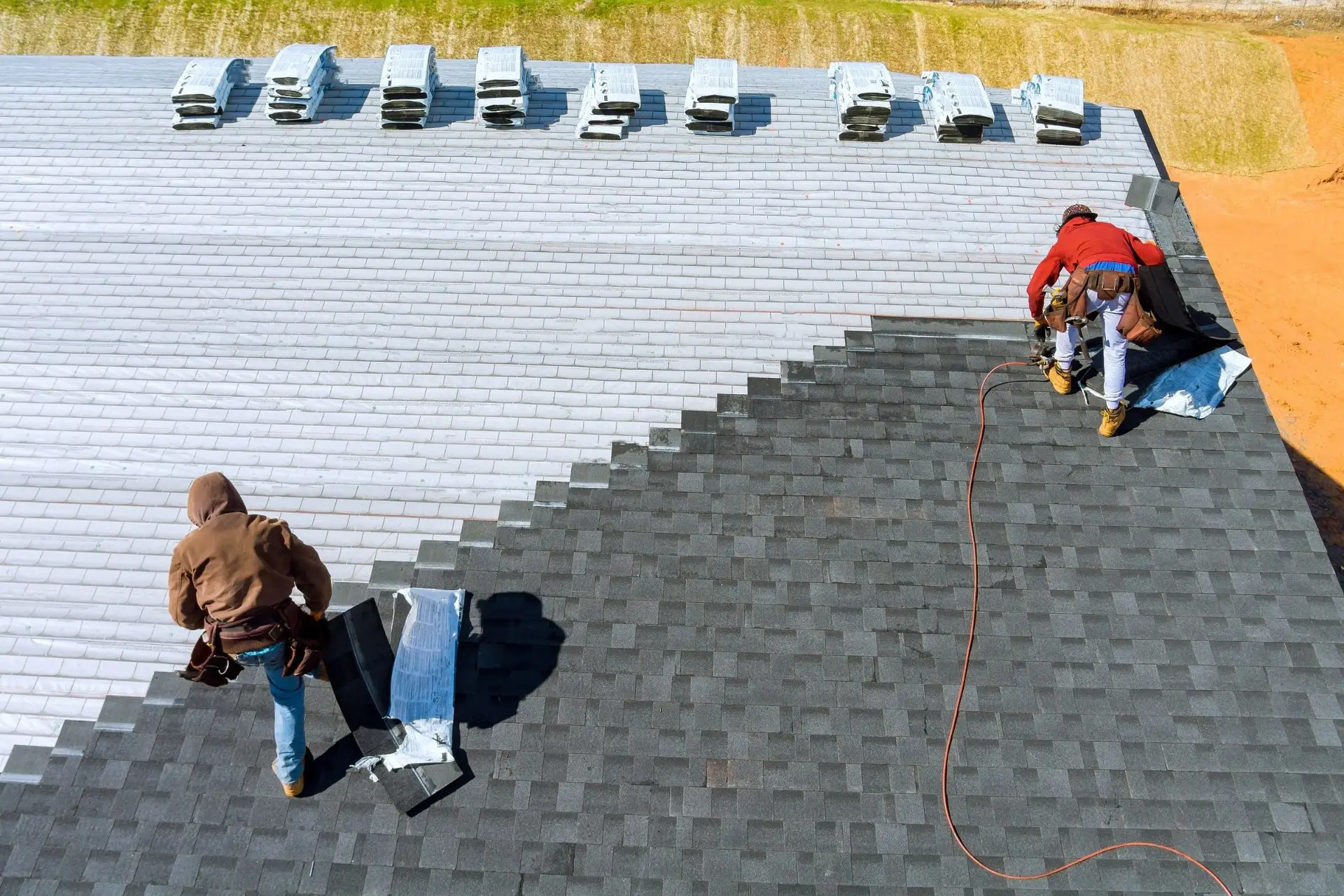 Roofers installing new shingles on a roof