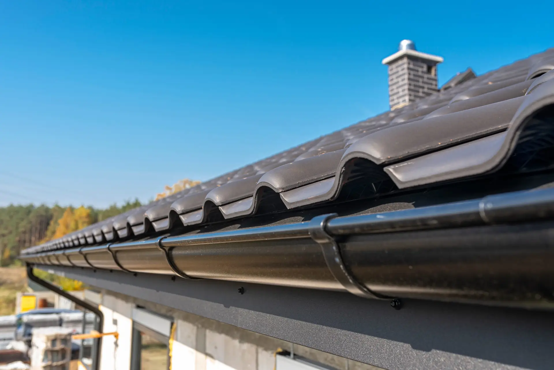 Black roof tiles with a gutter on a new home