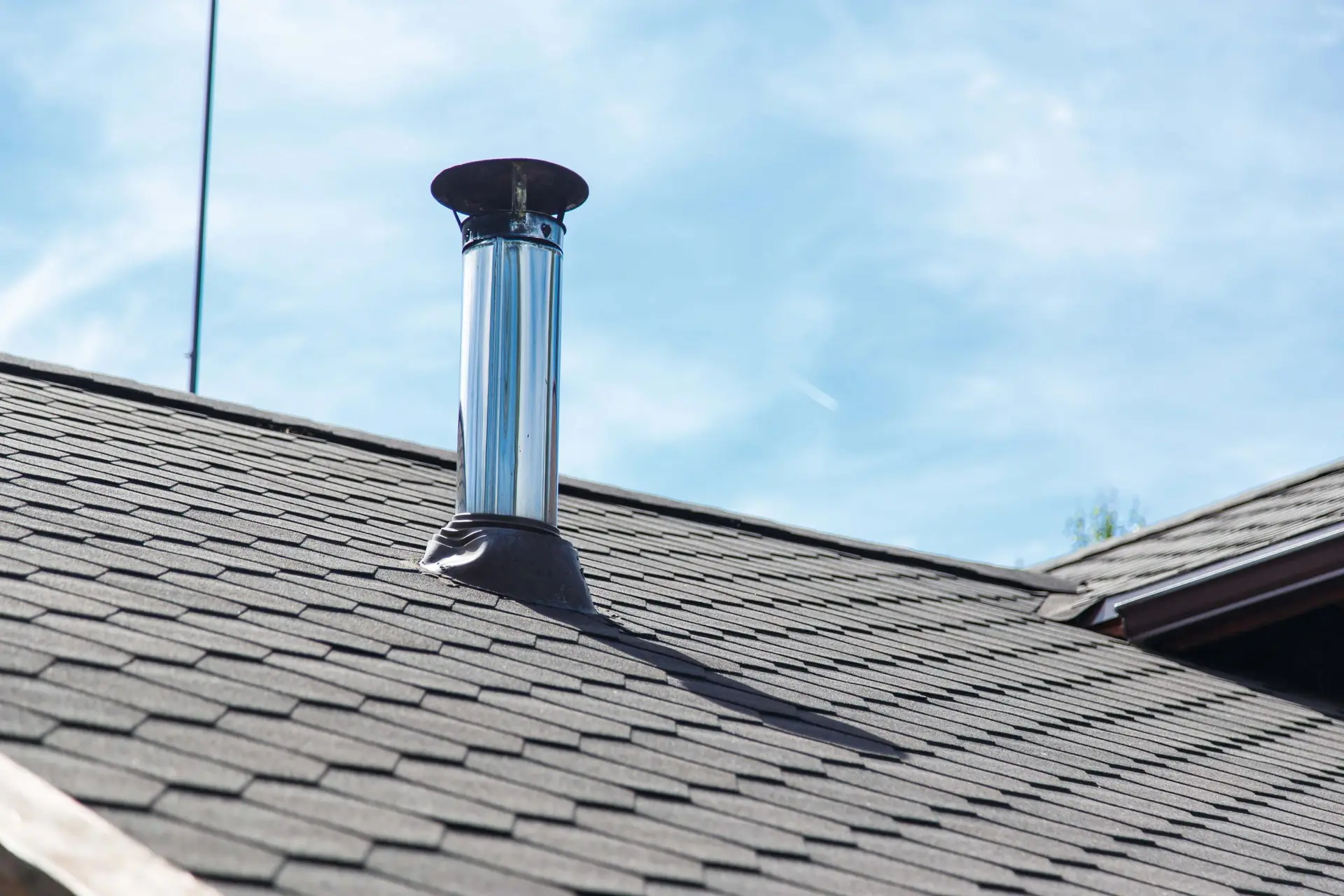 Chimney flue pipe on a shingled roof
