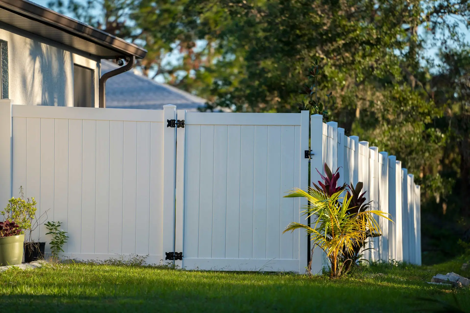 White privacy fence with a gate in a backyard