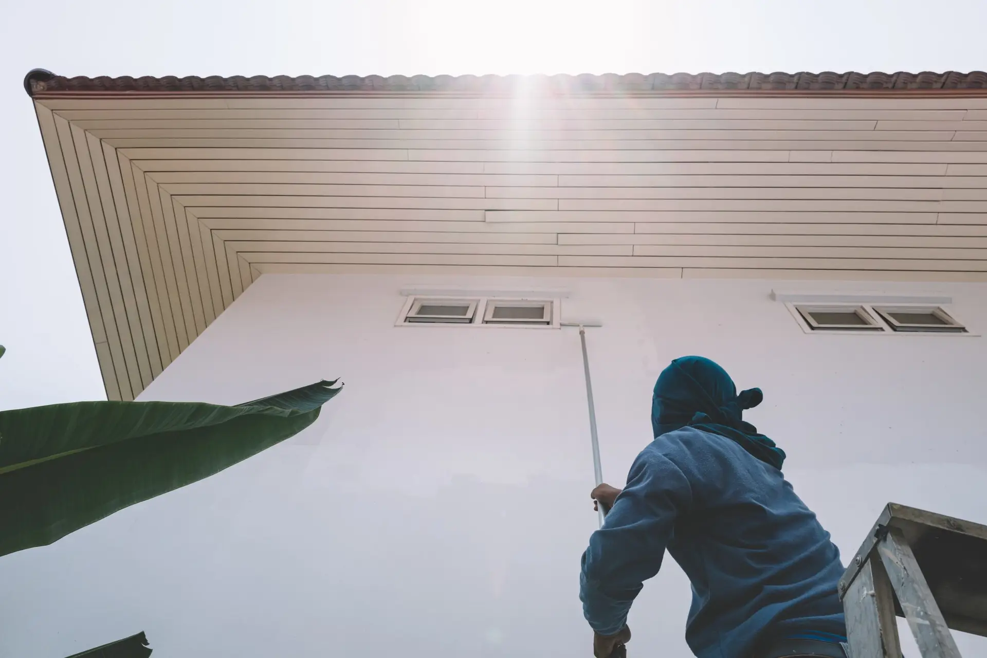 Painter using a roller on an exterior wall