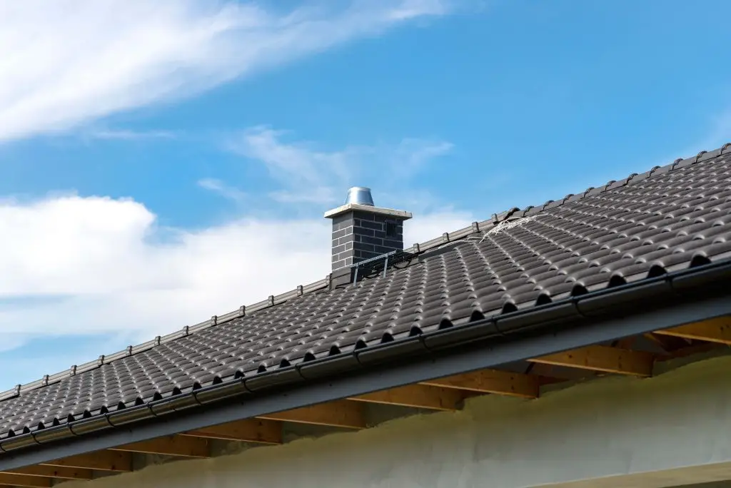 Dark tile roof with a chimney