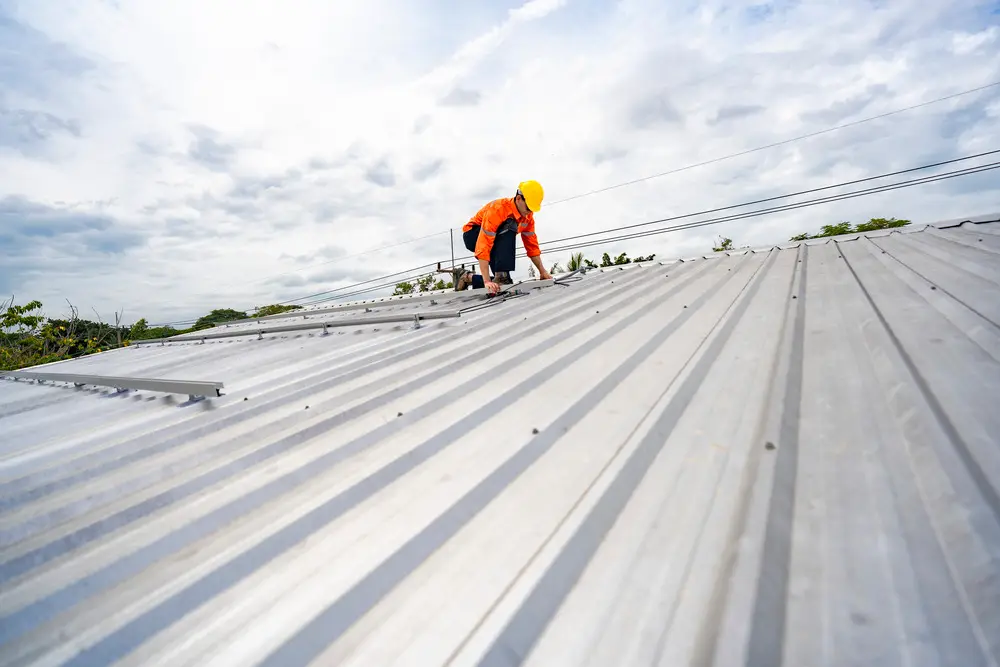 Roofer working on a metal roof