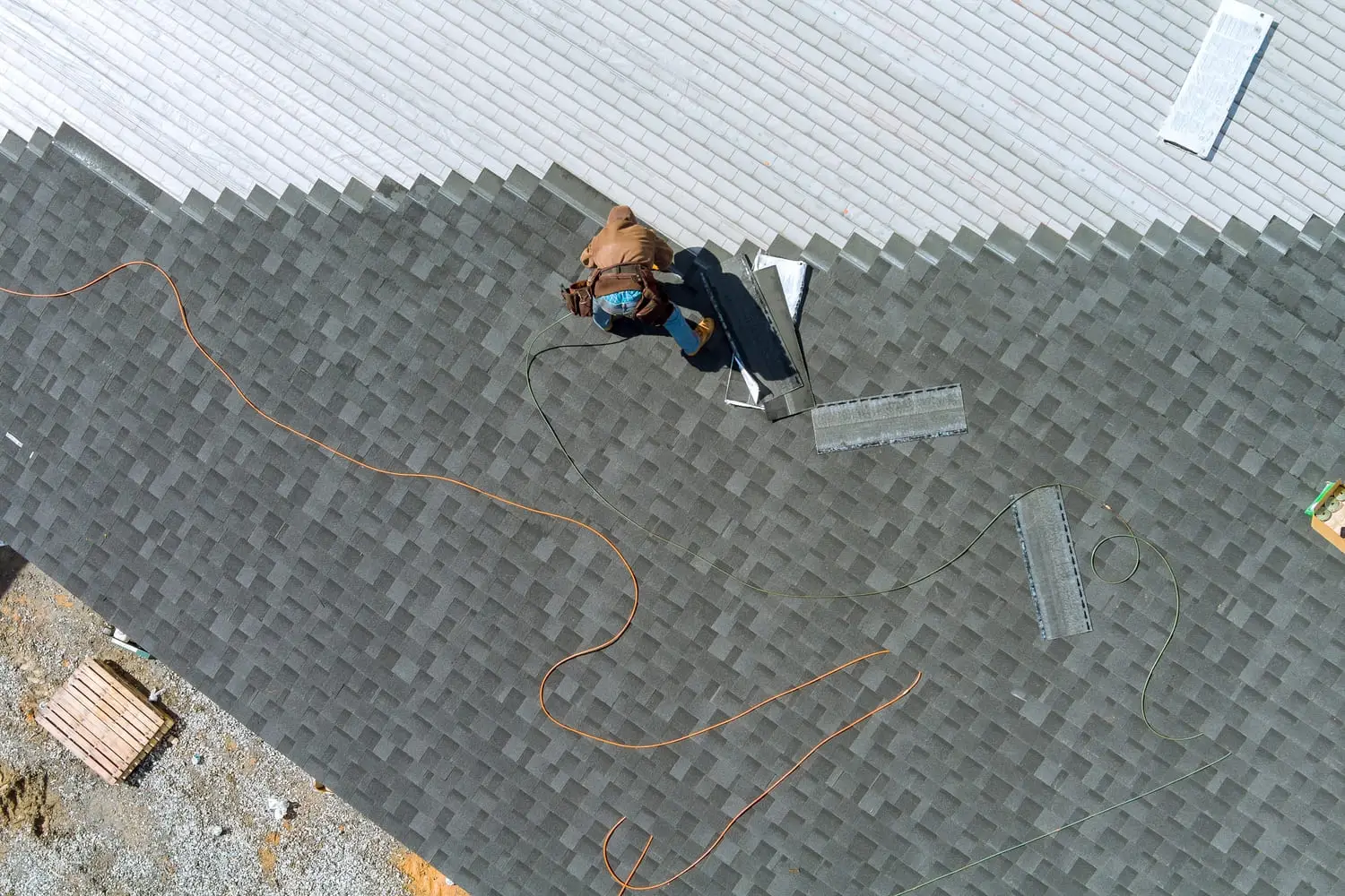 Roofer installing shingles on a new roof