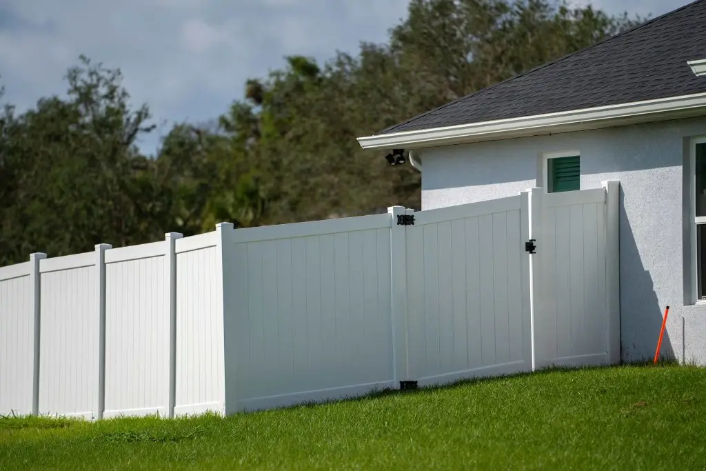 White vinyl privacy fence beside a house