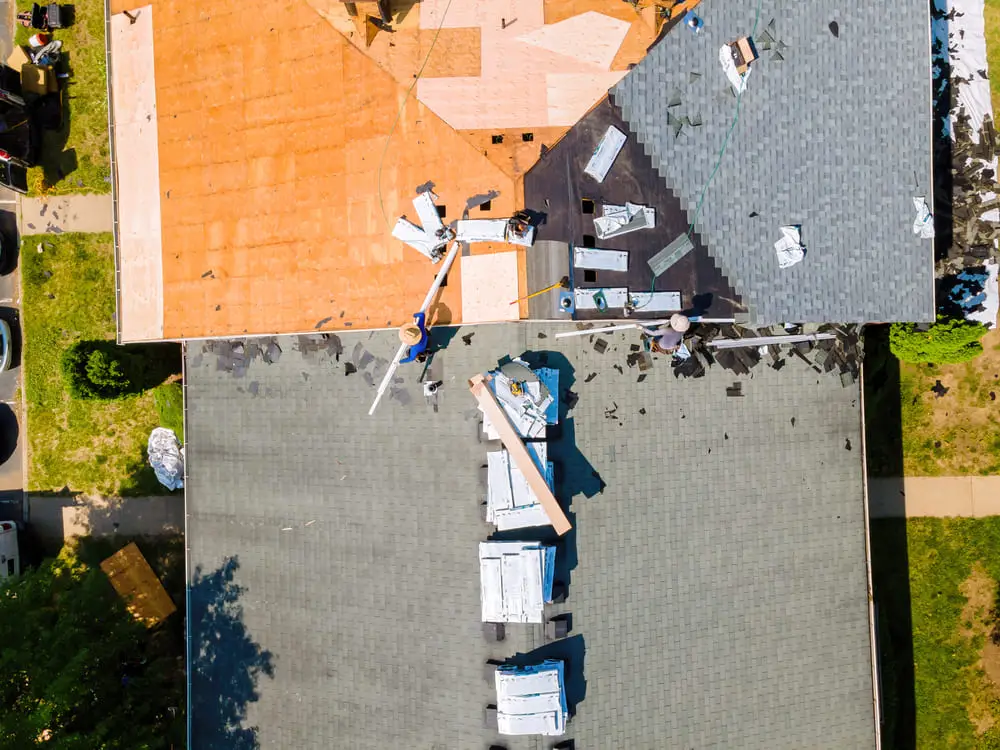 Aerial view of workers repairing a storm-damaged roof