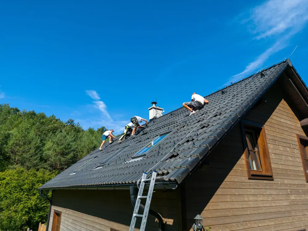 Workers repairing the roof of a house